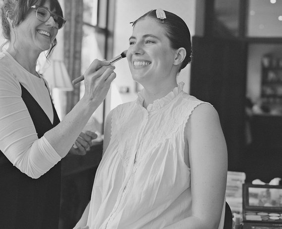 Bride sitting in front of Makeup Artist Heather Snowie getting her makeup done 