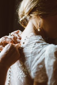 Buttoning a custom Boston wedding gown