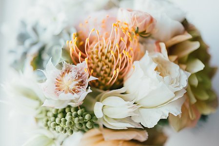 Beautiful floral arrangement with seed heads and orange and gold accents.