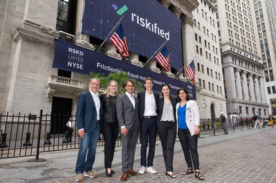 Company's executives standing in front of New York Stock Exchange, featuring a huge company logo