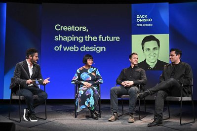 4 people conversing on stage at a company event panel discussion, sitting on chairs