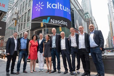 company executives standing in front of the NASDAQ billboard in times square 