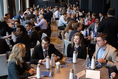 groups of people conversing around round tables at company sales event