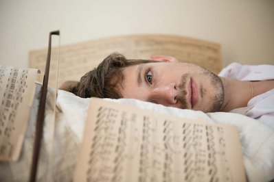 portrait of Hanno Hauenstein laying on a bed with music notes around him