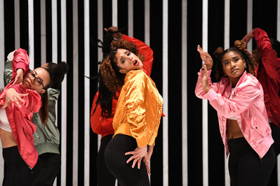 young female hip-hop dancers wearing colorful jackets dancing