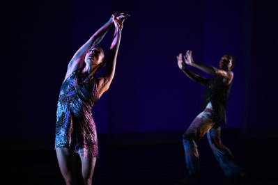 dancers dancing under purple light 