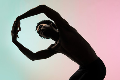 a silhouette of a male dancer with a colorful gradient background at The Ailey School