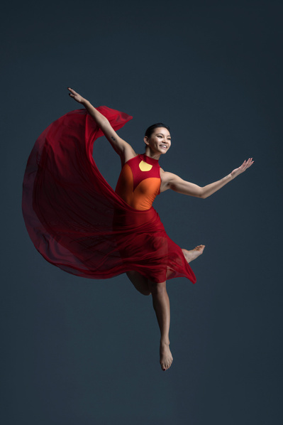 female dancer jumping in a red dress at The Ailey School

