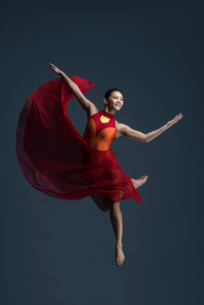 female dancer jumping in a red dress at The Ailey School

