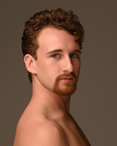 Headshot of a dancer on a brown background at the Ailey School