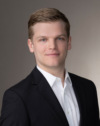 a corporate headshot on a gradient grey background