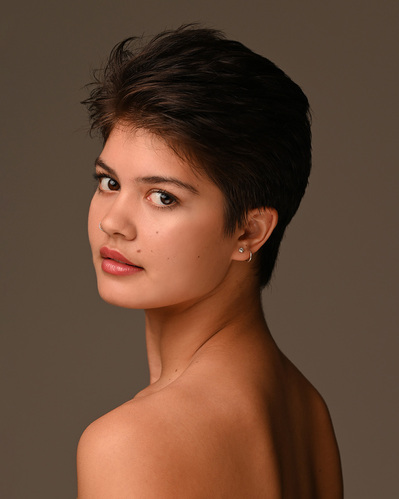 Headshot of a dancer on a brown background at the Ailey School