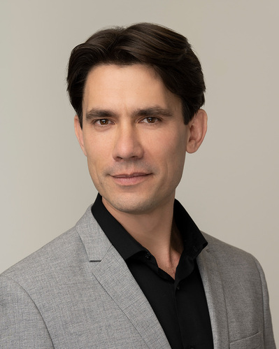 a corporate headshot on a grey background