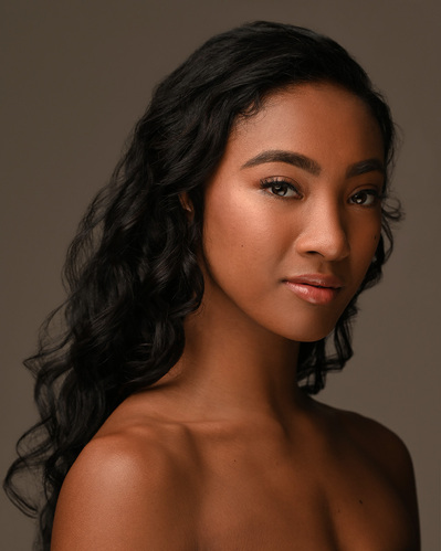 Headshot of a dancer on a brown background at the Ailey School