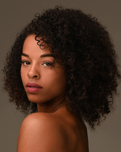 Headshot of a dancer on a brown background at the Ailey School