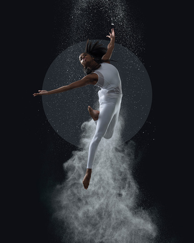 female Dancer jumping with dust behind  at The Ailey School