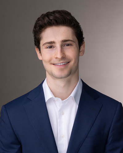 a corporate headshot on a gradient grey background