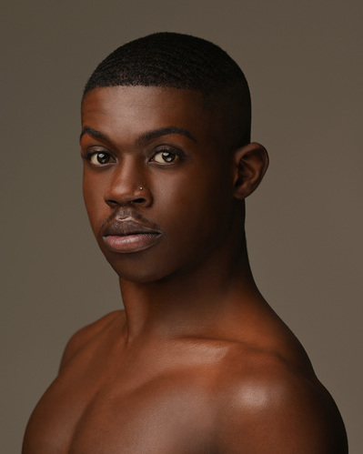 Headshot of a dancer on a brown background at the Ailey School