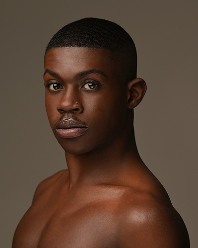 Headshot of a dancer on a brown background at the Ailey School