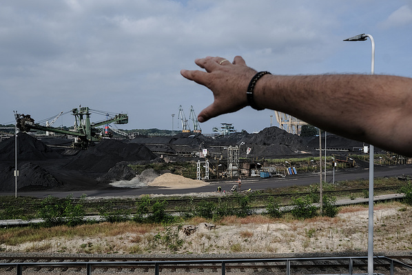 Tomasz Maślanka, resident of Świnoujście, showing the heaps of coal at the fuel teminal. The coal regularly catches fire and the accompanying fumes cause health hazards for local residents and safety hazards for fuel terminal infrastructure. Świnoujście,