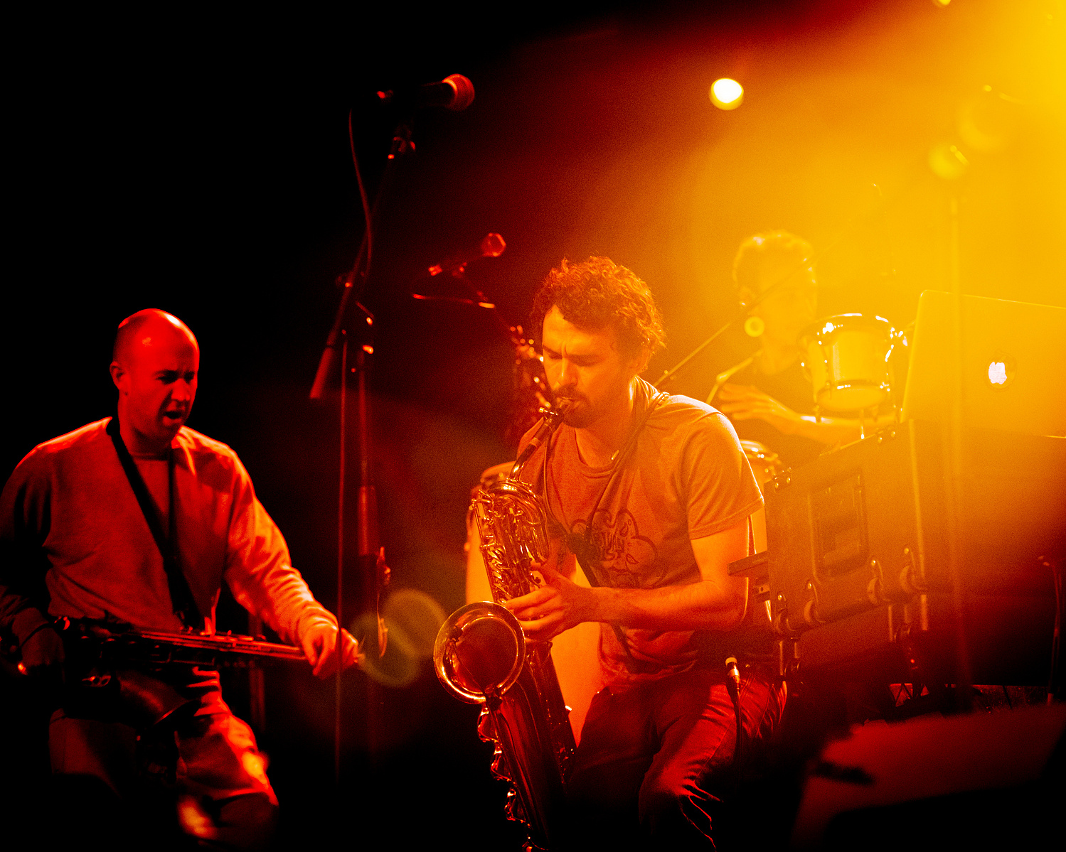 two musicians on stage in warm red and yellow light
