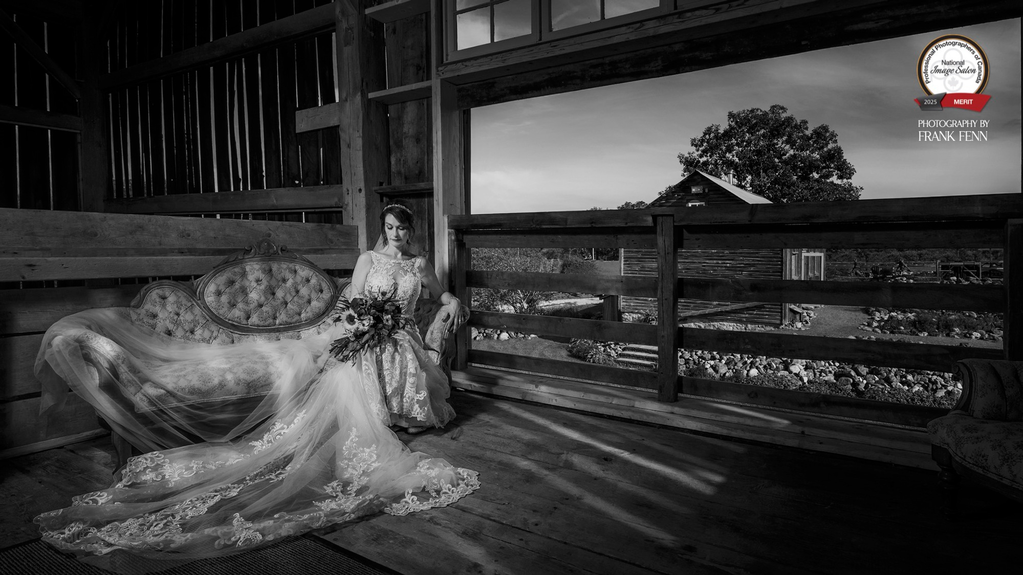 Bride seated on chaise lounge in barn loft at Ecotay in Perth, Ontario, photographed in black & white by Accredited Professional Wedding Photographer. Frank Fenn
