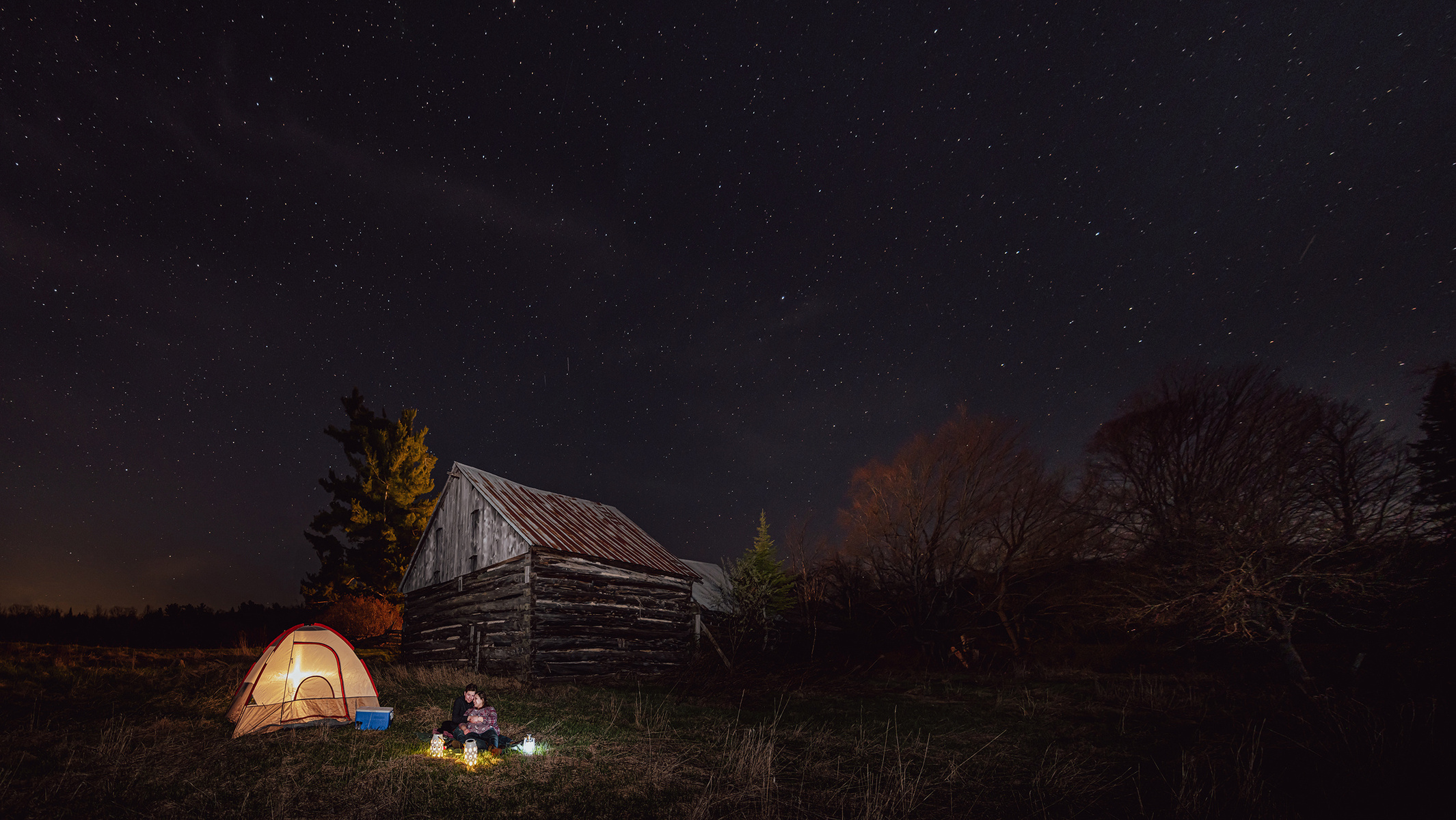 Couple posed under the stars with tent engagement session in Renfrew County
