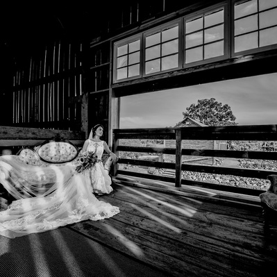 Wedding photograph of bride in black and white reclining on settee in barn loft at Ecotay by Smiths Falls photographer Frank Fenn