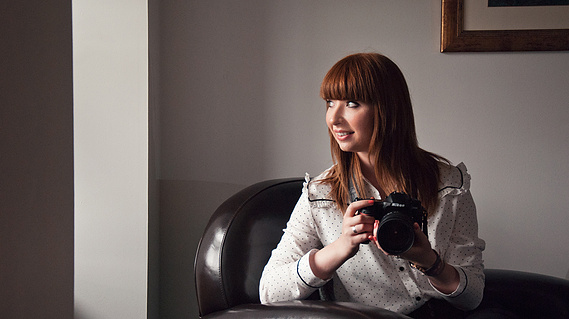 Personal branding photographer Karina Lyburn holding a camera, by Anne Lyburn