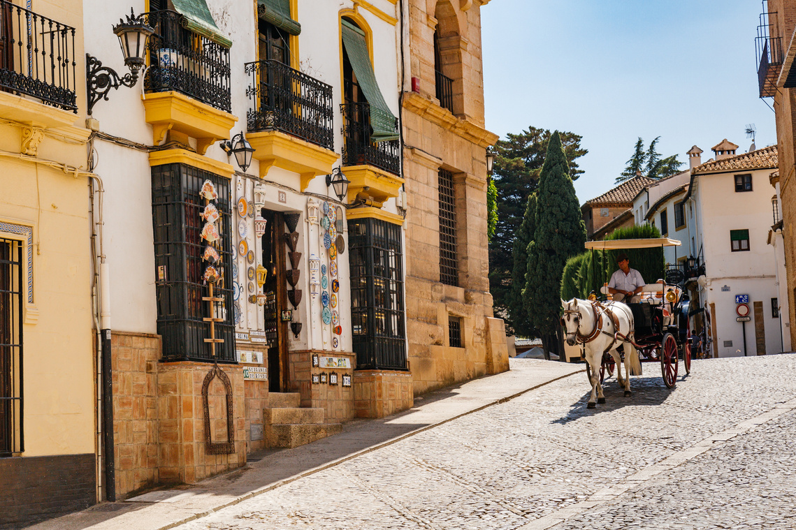 Horse drawn carriage heading down the cobbled streets of Ronda, Spain