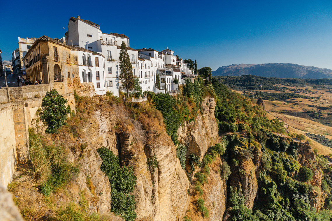View of the houses and shops atop the hillside of El Tajo gorge in Ronda, Spain