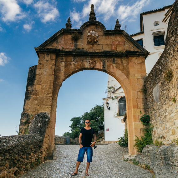 Jason Lee standing under an archway while wandering around Ronda, Spain