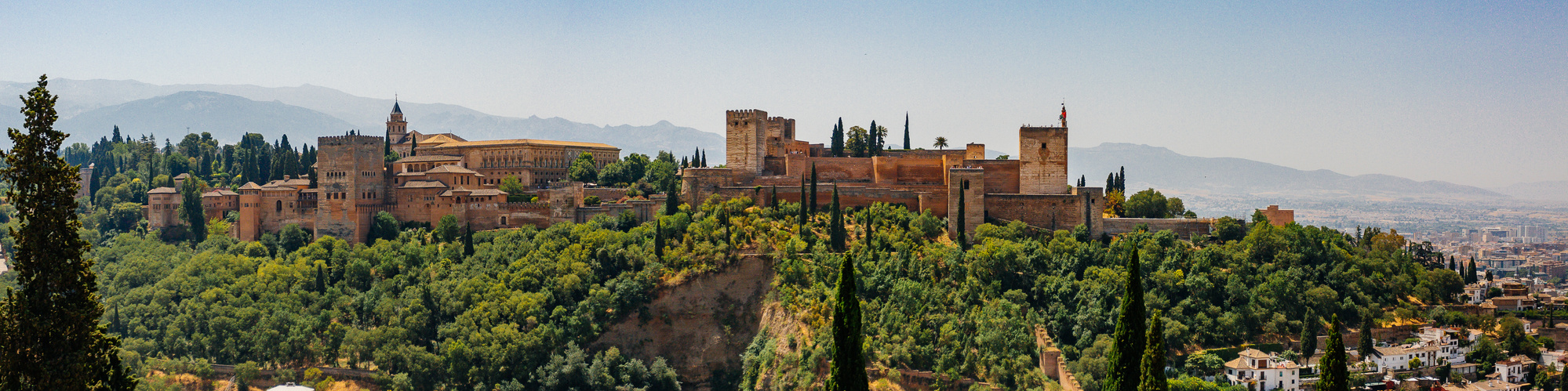 Panoramic view of the whitewashed buildings and green hillside of Setenil de las Bodegas, Spain 