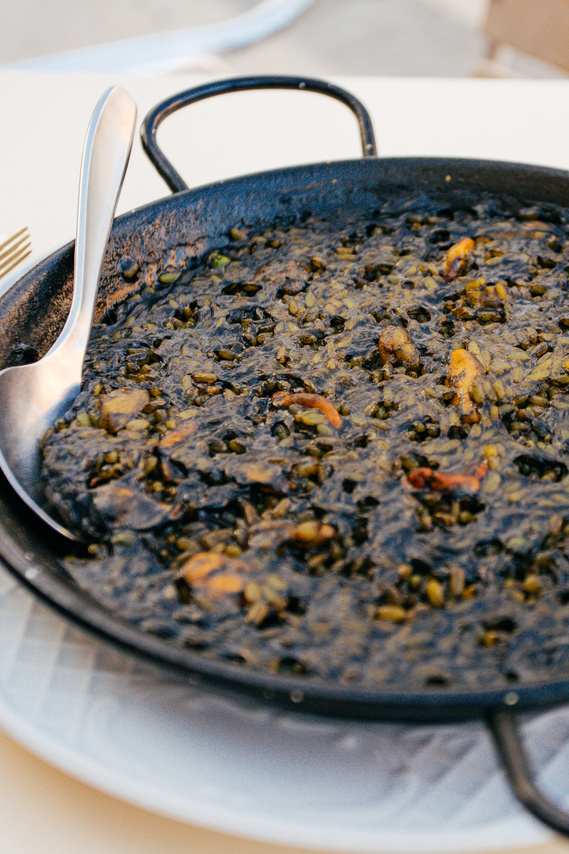 Close up image of Squid ink paella served in a cast iron skillet in Ronda, Spain