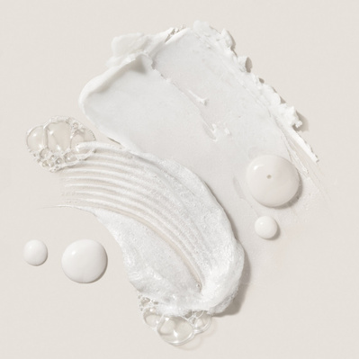 A macro shot showcasing Deinde’s skincare textures with airy bubbles and fluid movement, representing the balance between nourishment and lightweight formulation. The creamy swatches highlight the brand’s focus on premium skincare application. 