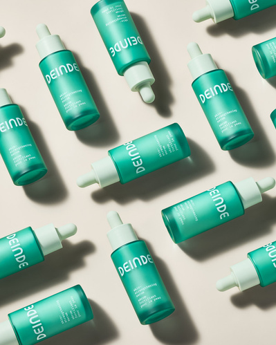A high-impact flat lay featuring Deinde skincare droppers, arranged in repetition to highlight product abundance. Photographed by Los Angeles product photographer Alex Kapustin at Rig Studio LA.
