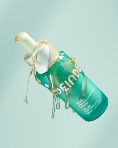 A striking product shot highlighting Deinde’s skincare serum infused with grapefruit extract, captured mid-air to emphasize its rich botanical formulation. Photographed by Los Angeles product photographer Alex Kapustin at Rig Studio LA.