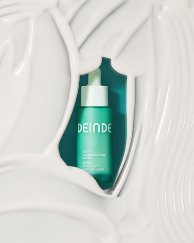 A conceptual skincare shot featuring Deinde serum emerging from a rich product smear, symbolizing hydration and renewal. Photographed by Los Angeles product photographer Alex Kapustin at Rig Studio LA.