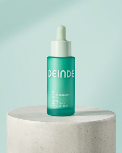A clean and refined studio shot of Deinde’s hydrating serum, placed on a concrete pedestal against a soft-toned background. Photographed by Los Angeles product photographer Alex Kapustin at Rig Studio LA
