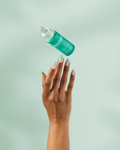 A clean beauty shot showcasing a Deinde serum bottle in mid-air, representing balance and skin hydration. Photographed by Los Angeles product photographer Alex Kapustin at Rig Studio LA.
