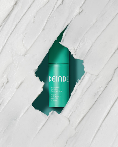 A striking composition featuring Deinde serum breaking through textured layers, symbolizing skin transformation and deep nourishment. Photographed by Los Angeles product photographer Alex Kapustin at Rig Studio LA.