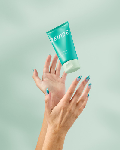 A visually striking shot featuring a Deinde skincare tube balanced in mid-air, emphasizing skincare as a seamless daily ritual. Photographed by Los Angeles product photographer Alex Kapustin at Rig Studio LA.