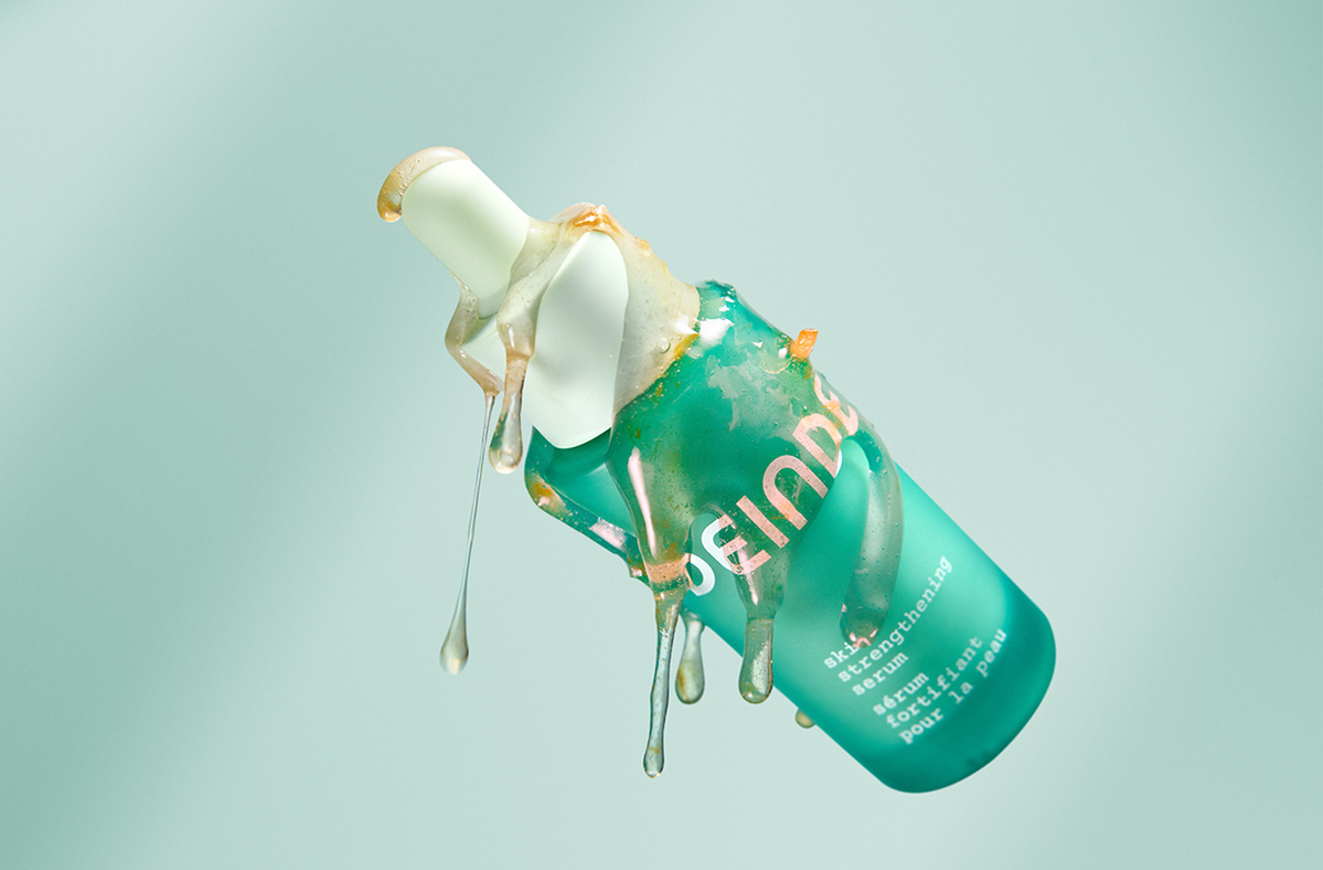 A striking product shot highlighting Deinde’s skincare serum infused with grapefruit extract, captured mid-air to emphasize its rich botanical formulation. Photographed by Los Angeles product photographer Alex Kapustin at Rig Studio LA.