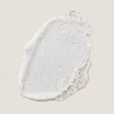 A refined product texture shot featuring a single swipe of Deinde skincare, accentuating the creamy consistency and rich hydration properties. The organic edges and subtle gloss reinforce the luxurious feel of the formula. 