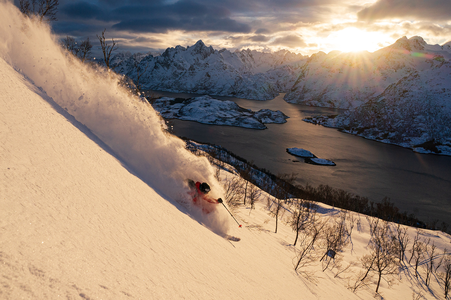Adam U powder skiing sunset in Lofoten Norway. 