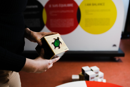 Une jeune femme tient un cube portant une illustration de tortue