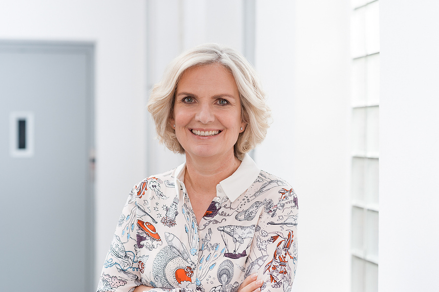 Professionelles Businessportrait mit moderner Ausstrahlung. Der helle Hintergrund und die lockere Haltung verleihen dem Bild Leichtigkeit. Ideal für Personal Branding, Karriere-Websites oder Unternehmensfotografie.