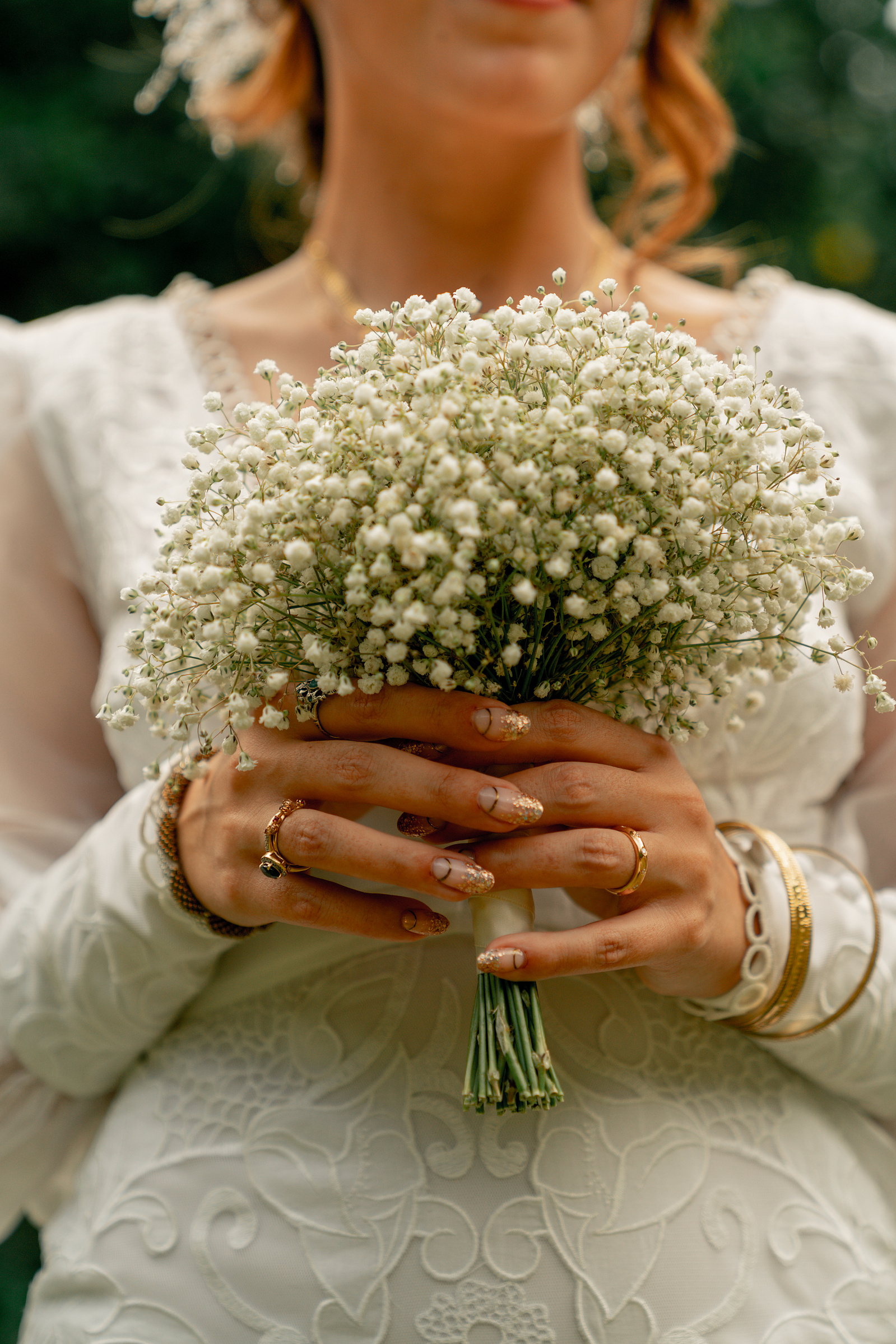 Mariée en robe tenant son bouquet avec des bagues et son alliance.