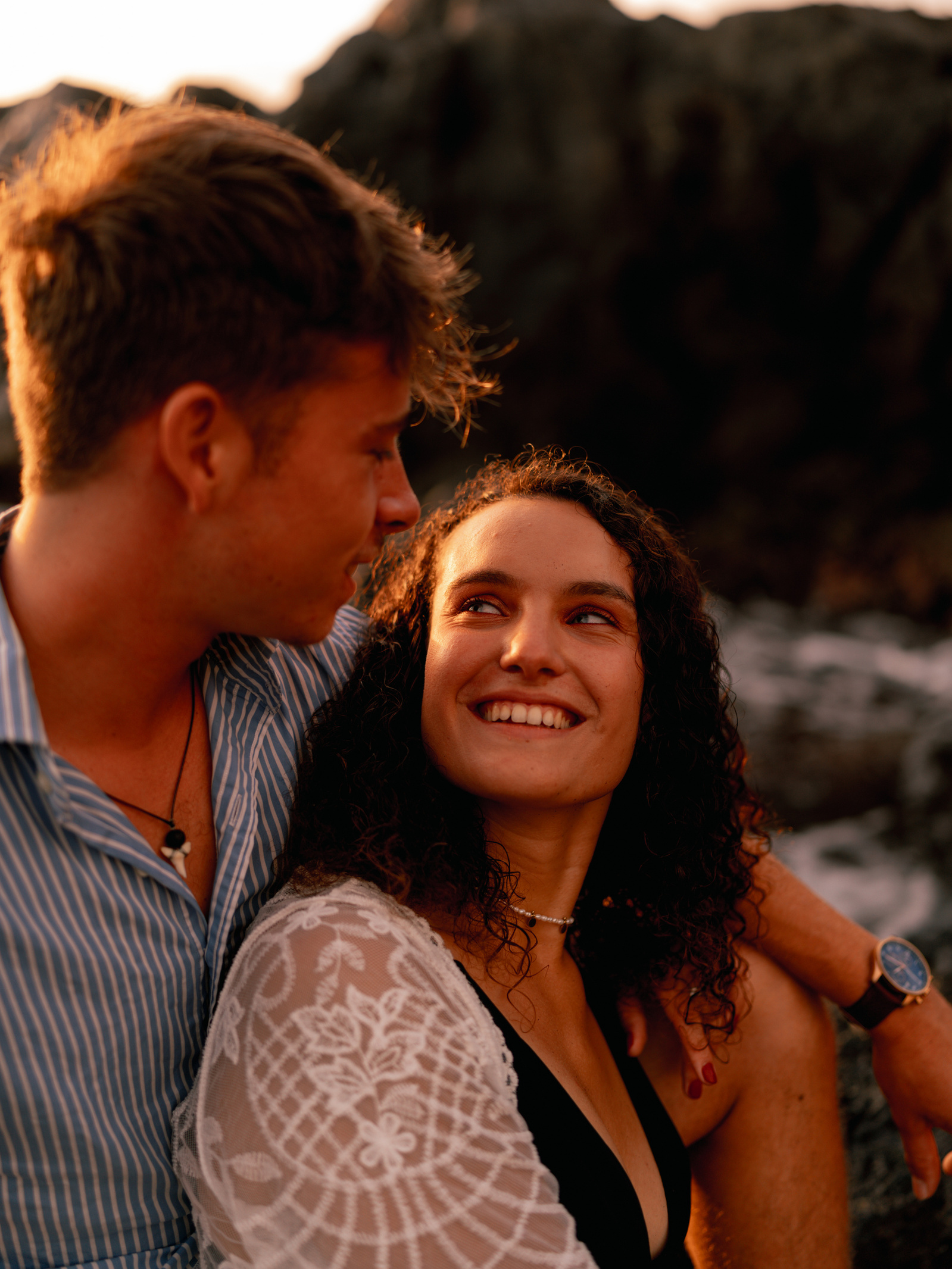 Un couple se regardant dans les yeux. La femme sourit à son compagnon. 