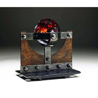 A steel sculpture with a blown glass globe held by steel bands